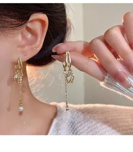 Detail of tulip flower earrings with gold hollow buds and long pearl tassels shown on model