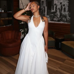 Detail of white halter neck dress with deep V-neck and flowing satin fabric texture