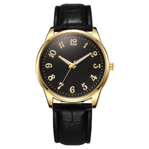 Dettaglio orologio al quarzo dorato con quadrante nero e cinturino in pelle