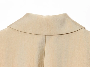 Detail van de goudkleurige blazer kraag met premium stoftextuur en fijne stiksel afwerking