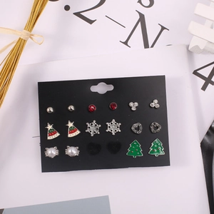 Detailansicht von neun Paar Weihnachtsohrringen mit Bäumen und Schneeflocken auf Karte
