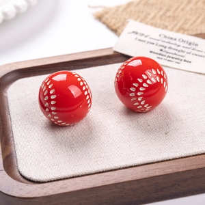 Macro d'oreilles de baseball en résine rouge avec coutures blanches sur support en bois
