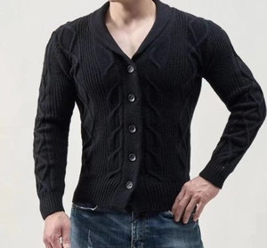 Detail der schwarzen Strickjacke mit klassischem Zopfmuster und V-Ausschnitt mit Knöpfen