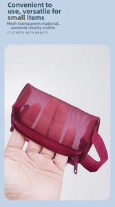 Detail of wine red translucent mesh coin purse showing zipper closure and side handle strap
