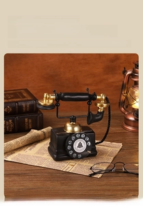 Macro shot of vintage resin telephone model with golden rotary dial and aged texture