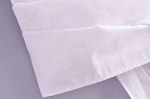Gros plan des coutures professionnelles et du tissu en coton blanc lisse sur la chemise