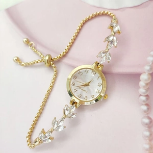 Détail du bracelet de montre doré en forme de feuille avec strass et fermoir réglable