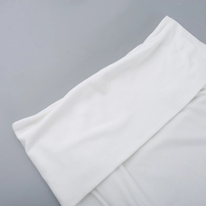 Detailed close-up of white ribbed knit fabric showing fine texture and clean folded edges