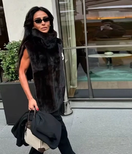 Photo style urbain d'un long gilet en fausse fourrure noire avec col haut sans manches