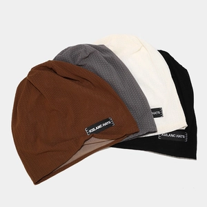 Set of four knitted beanie hats in brown, grey, cream and black with breathable texture
