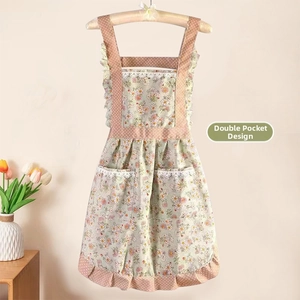 Détail du tablier floral en toile avec poches à dentelle et volants à pois contrastés