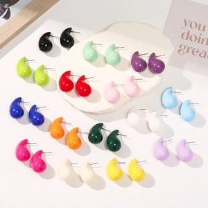 Flat lay of colorful teardrop earrings in 15 vibrant glossy lacquer finishes on white stone