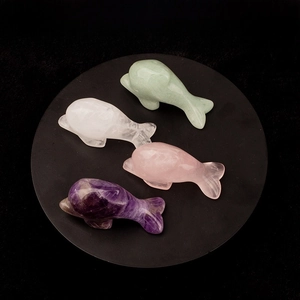 Detailed view of four natural crystal dolphin carvings including amethyst and rose quartz