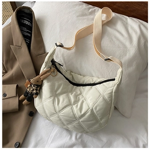 Detailed view of cream white quilted hobo bag with adjustable strap and bunny charm