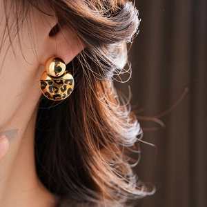 Close-up of leopard print heart earrings on model showing premium gold plating and detail
