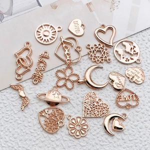 Macro view of assorted antique gold metal charms including sun, moon, and heart shapes