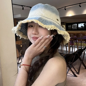 Blue gradient frayed denim bucket hat for women with sun protection in a casual cafe setting