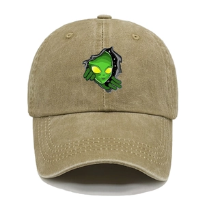 Close-up of alien embroidery and distressed fabric on a khaki vintage baseball cap