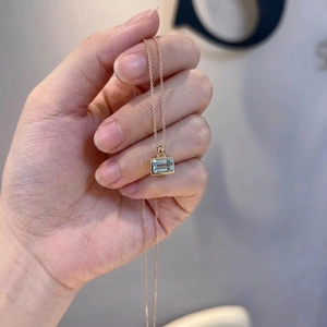 Minimalist 925 silver necklace with rectangular aquamarine crystal pendant held by hand