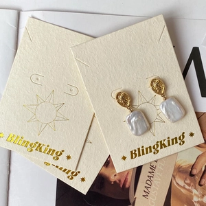 Vintage gold coin earrings with baroque pearls displayed on a premium jewelry card
