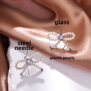 Macro shot of bow-shaped earrings featuring faux pearls and sparkling crystal centers