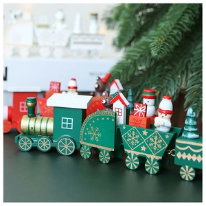 Close-up of green wooden Christmas train with snowman and bear figurines on cars