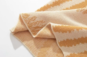 Dettaglio del tessuto in maglia a righe arancioni e beige con texture morbida ed elastica