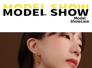 Detail showing long golden oval-link chain earrings worn by a model for a stylish look