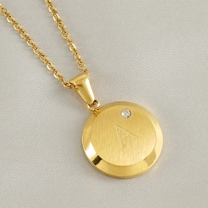 Close-up of 18K gold letter A pendant with brushed finish and sparkling small diamond