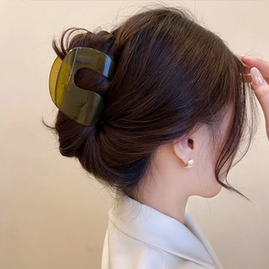 Minimalist large dark green translucent shark hair claw clip shown on model's hair