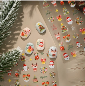 Detailed view of Christmas nail art stickers with watercolor reindeer and snowman patterns