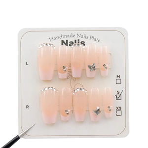 Faux ongles faits main dégradé rose avec papillon argenté et accents de strass blancs