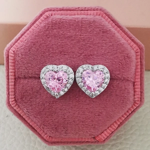 Macro shot of heart-shaped pink zircon earrings in a premium pink velvet jewelry box