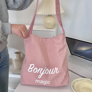 Borsa a tracolla in tela rosa con scritta Bonjour Magic e dettagli della tracolla a righe