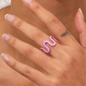 Close-up of 18K gold-plated wavy ring with purple enamel detail on model's finger