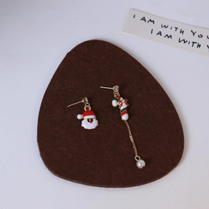 Detail of asymmetric Christmas earrings with Santa Claus, candy cane and pearl charms