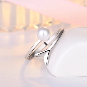Detail of adjustable silver ring featuring a white pearl and hollow fish tail design