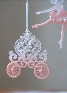 Close-up of pink gradient pumpkin carriage ornament with white ribbon for Christmas tree