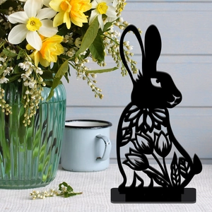 Detail of black metal Easter bunny stand featuring hollow tulip patterns on beige fabric