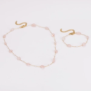 Detail of gold chain necklace and bracelet with pink crystals and small white pearls