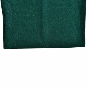 Close-up of dark green dress fabric featuring shimmering metallic glitter and rich texture