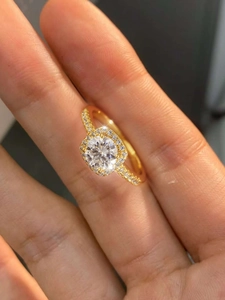 Close-up of golden S925 silver cushion cut moissanite ring with a sparkling halo