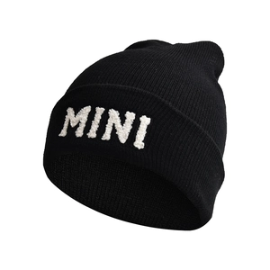 Close-up of black knitted beanie with white MINI letter embroidery on white background