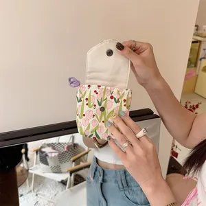 Close-up of portable tulip floral mini storage bag with snap button held in hand