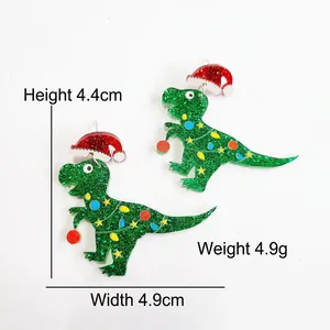 Detail of green glitter acrylic Christmas dinosaur earrings with festive light patterns