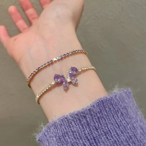 Détail du bracelet papillon en cristal violet et ensemble chaîne tennis plaqué or