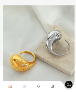 Macro detail of gold and silver organic drop rings with micro-set zircons on a stone base