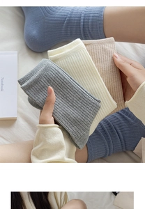 Close-up of ribbed cotton crew socks in grey, beige, khaki, and dusty blue colors