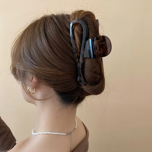 Close-up of a large leopard print hair claw clip in a stylish updo hairstyle