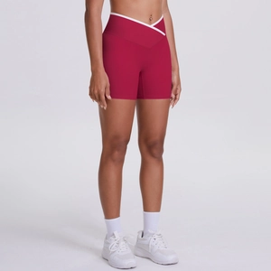 Close-up of high-waisted red yoga shorts featuring a V-shaped crossover waistband design
